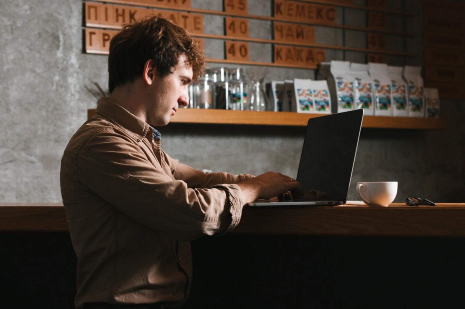 Student working through financial analysis coursework on laptop with study materials